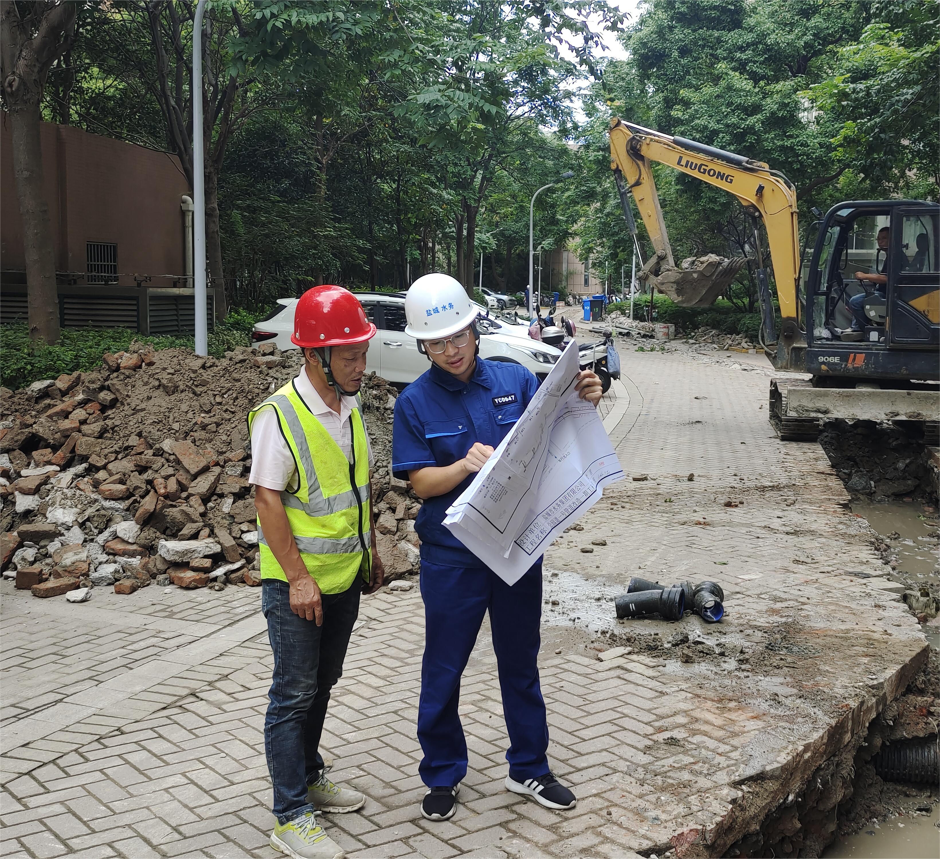 孟偉(右一)在公園道一號(hào)小區(qū)組織施工方按圖施工.jpg